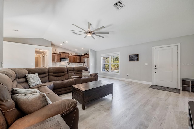 living room featuring visible vents, baseboards, ceiling fan, vaulted ceiling, and light wood-style flooring