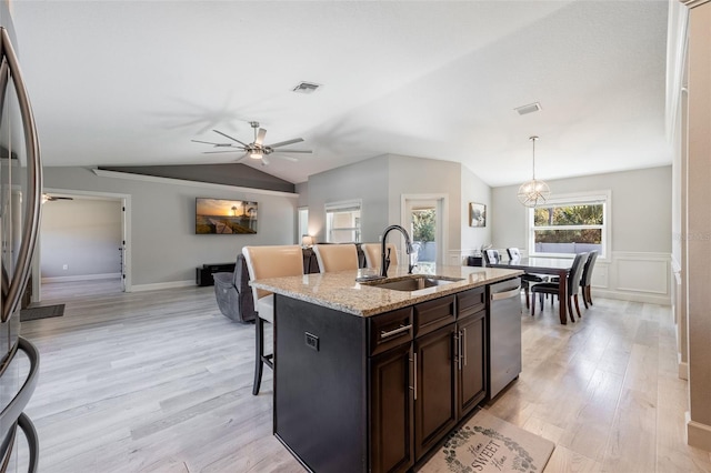 kitchen with a kitchen bar, visible vents, a ceiling fan, a sink, and stainless steel appliances