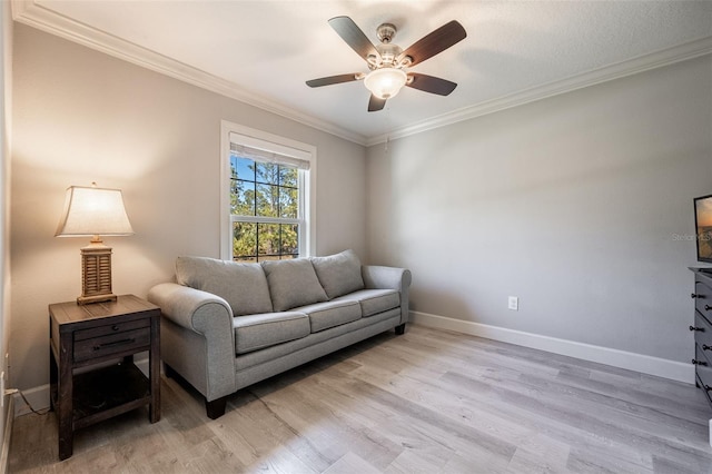 living room featuring ceiling fan, light wood-style flooring, baseboards, and ornamental molding