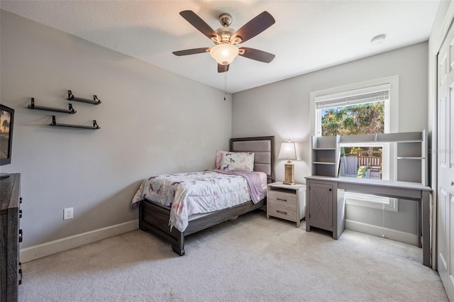 bedroom with light carpet, a ceiling fan, and baseboards