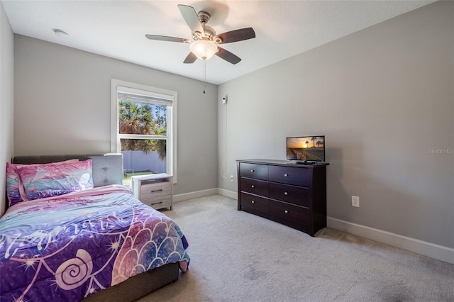 bedroom featuring baseboards, light colored carpet, and ceiling fan