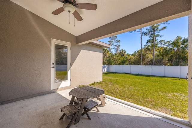 view of patio with ceiling fan and fence