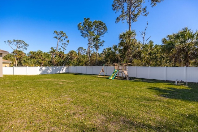 view of yard with a fenced backyard and a playground