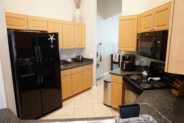 kitchen with light brown cabinetry, light tile patterned floors, black appliances, and dark countertops