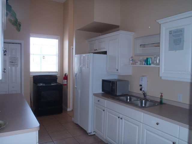 kitchen featuring white cabinetry, black appliances, light tile patterned floors, and a sink