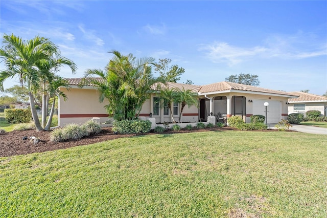 view of front of home with an attached garage, stucco siding, a front lawn, concrete driveway, and a tile roof