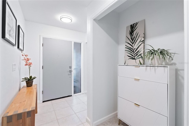 corridor featuring light tile patterned floors and baseboards