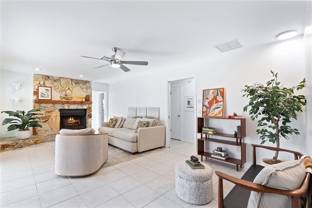 living area featuring visible vents, a ceiling fan, light tile patterned flooring, and a fireplace