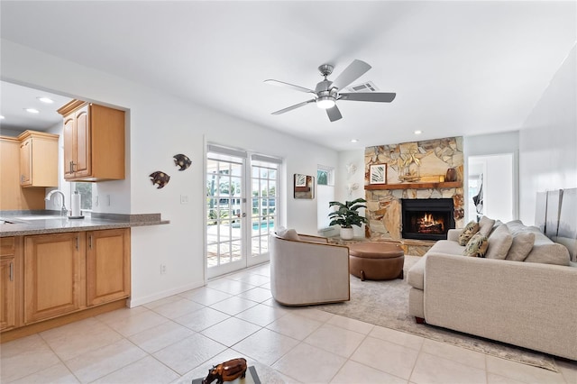 living room featuring recessed lighting, french doors, light tile patterned flooring, a fireplace, and ceiling fan