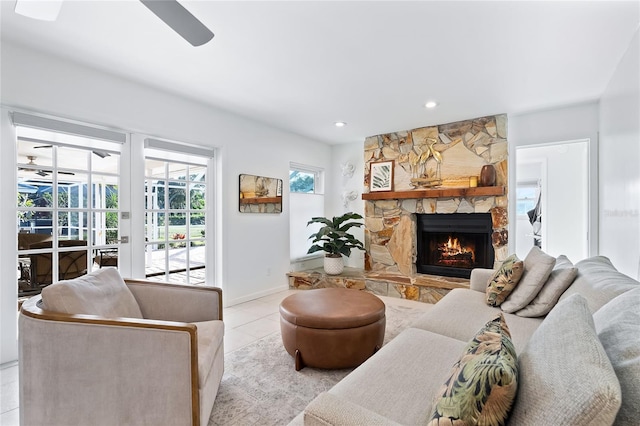 living room with baseboards, ceiling fan, a stone fireplace, recessed lighting, and tile patterned floors