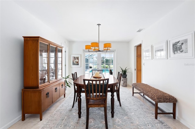 dining area featuring light tile patterned flooring, visible vents, baseboards, and an inviting chandelier