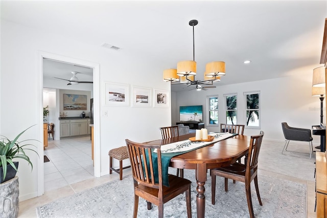 dining space featuring light tile patterned floors, visible vents, and ceiling fan with notable chandelier