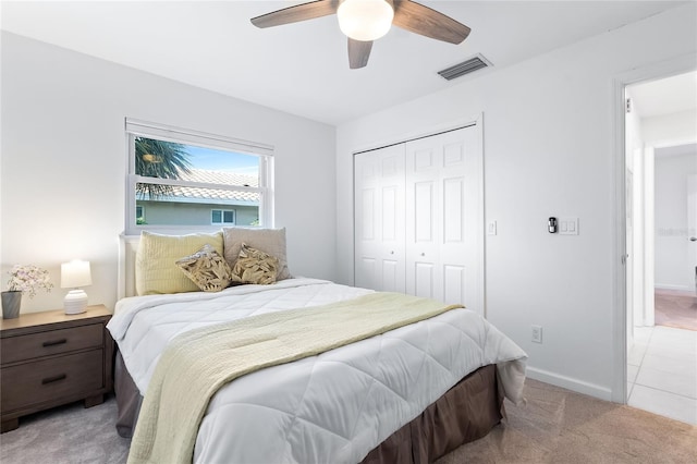 bedroom featuring visible vents, light carpet, a ceiling fan, a closet, and baseboards