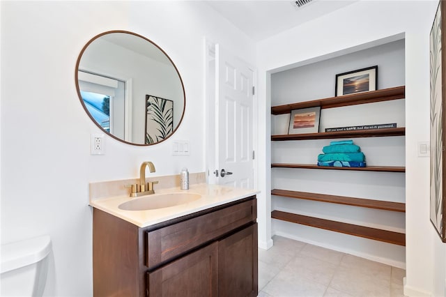 bathroom with toilet, vanity, and baseboards