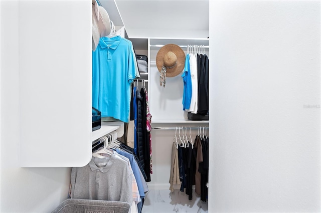 walk in closet featuring marble finish floor