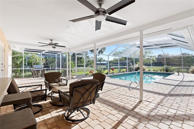 outdoor pool with a lanai, a ceiling fan, and a patio area