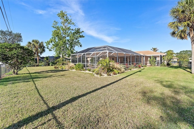 view of yard with glass enclosure and fence