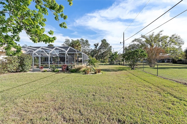 view of yard with a lanai and fence