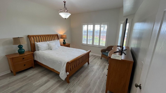 bedroom featuring light wood-type flooring and baseboards