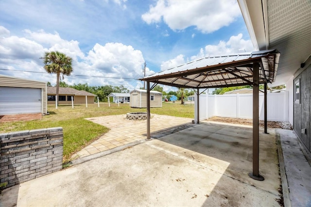 18348 Yale Ave, Port Charlotte, FL 33948 - view of patio with an outdoor fire pit, a gazebo, an outdoor structure, concrete driveway, and a detached carport