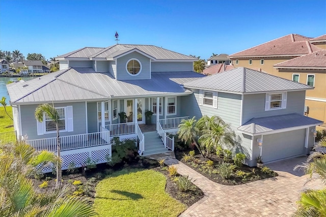 810 Siesta Dr, Sarasota, FL 34242 - view of front of property featuring covered porch, metal roof, an attached garage, decorative driveway, and a residential view