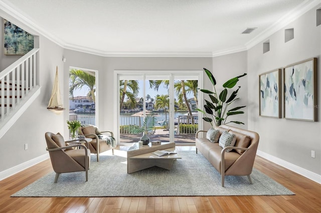 810 Siesta Dr, Sarasota, FL 34242 - living room featuring hardwood / wood-style floors, ornamental molding, baseboards, a water view, and stairs