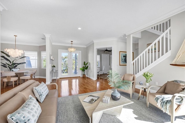 810 Siesta Dr, Sarasota, FL 34242 - living room with stairs, wood finished floors, a chandelier, baseboards, and ornamental molding