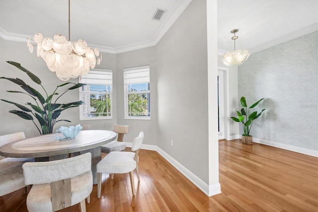 810 Siesta Dr, Sarasota, FL 34242 - dining room with light wood-style floors, wallpapered walls, a chandelier, baseboards, and crown molding