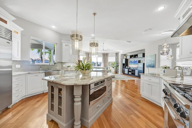 810 Siesta Dr, Sarasota, FL 34242 - kitchen featuring a sink, high quality appliances, a chandelier, decorative backsplash, and glass insert cabinets