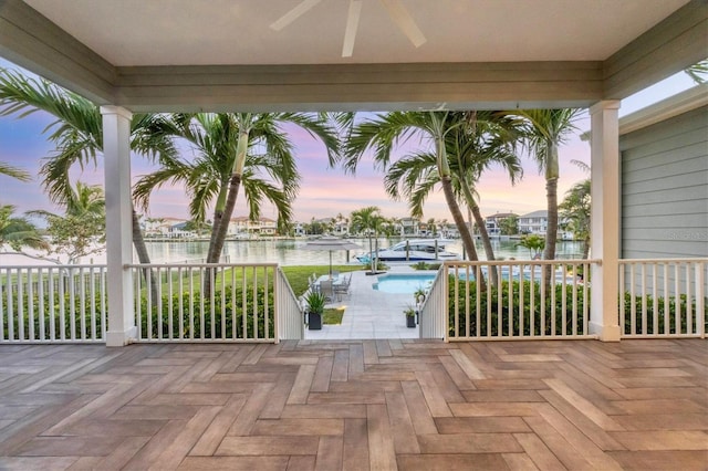 810 Siesta Dr, Sarasota, FL 34242 - patio terrace at dusk with a water view, an outdoor pool, ceiling fan, and a patio