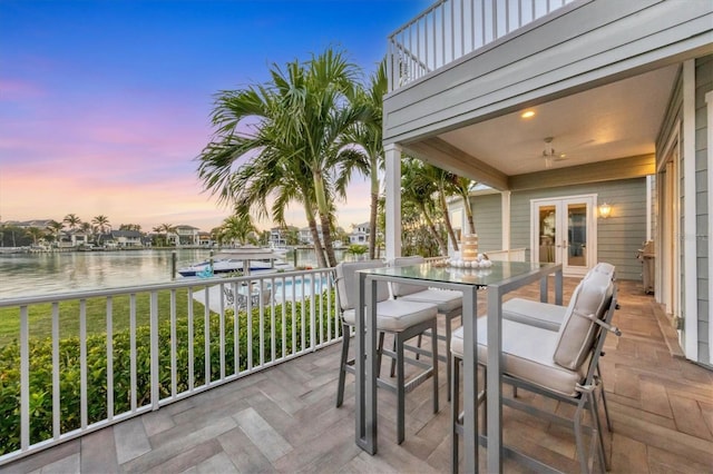 810 Siesta Dr, Sarasota, FL 34242 - deck at dusk featuring french doors, a water view, outdoor dining space, and a dock