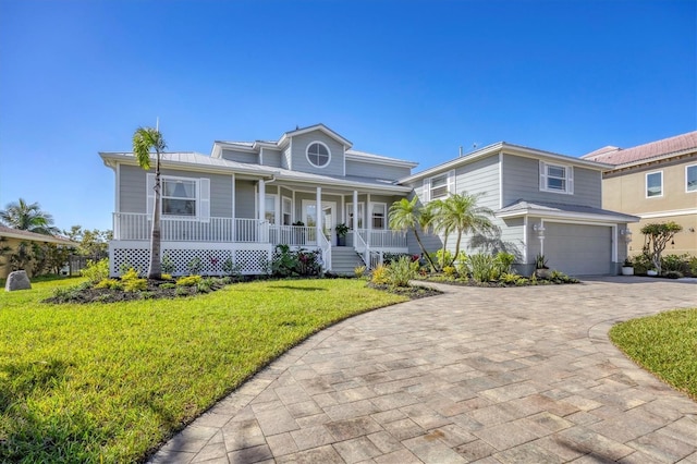 810 Siesta Dr, Sarasota, FL 34242 - traditional home with covered porch, a front yard, driveway, and an attached garage