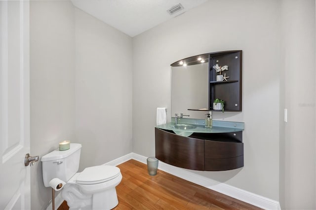 810 Siesta Dr, Sarasota, FL 34242 - bathroom with toilet, wood finished floors, double vanity, and baseboards