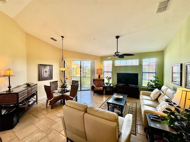 living area featuring stone tile flooring, visible vents, a ceiling fan, and vaulted ceiling