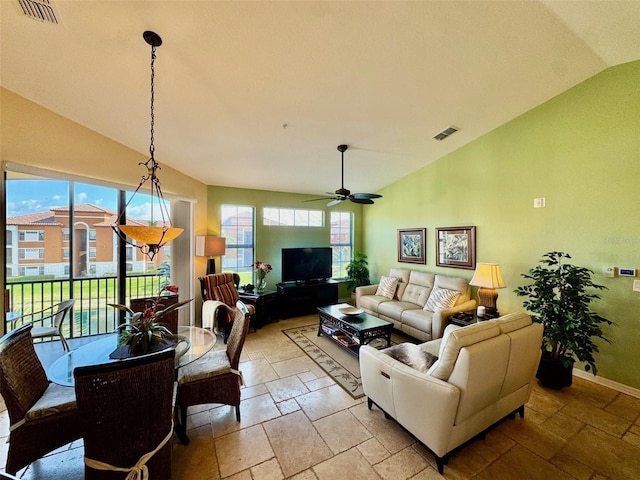 living room with stone tile floors, visible vents, baseboards, and vaulted ceiling