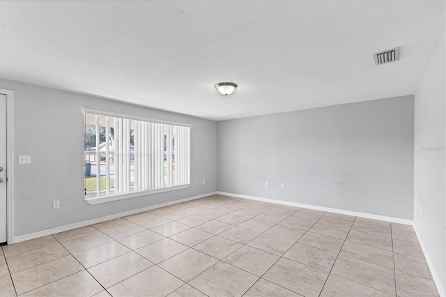 unfurnished room featuring baseboards and visible vents