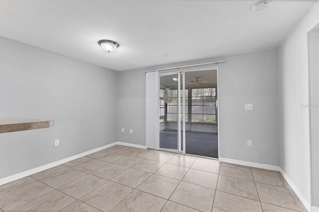 spare room featuring baseboards, a ceiling fan, and tile patterned flooring