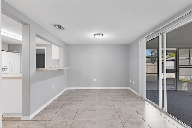 unfurnished room featuring light tile patterned flooring, baseboards, and visible vents