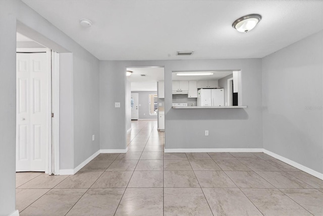 tiled empty room with visible vents and baseboards