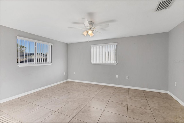 spare room featuring visible vents, baseboards, a ceiling fan, and tile patterned flooring