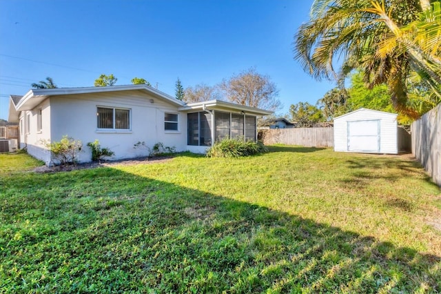 back of property featuring a yard, an outbuilding, a fenced backyard, and a storage shed