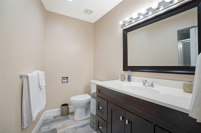 full bath featuring visible vents, toilet, wood finished floors, a shower stall, and vanity