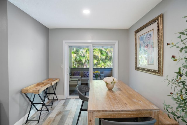 dining space featuring baseboards and light wood-style floors