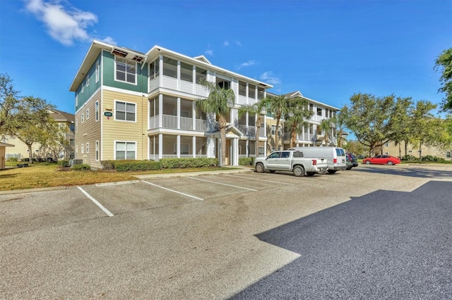 view of property featuring cooling unit and uncovered parking