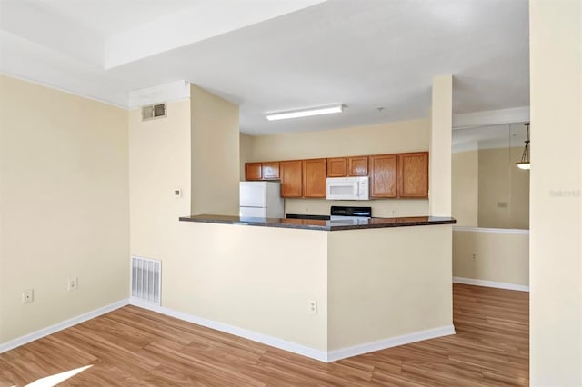 kitchen with visible vents, white appliances, brown cabinets, and light wood finished floors