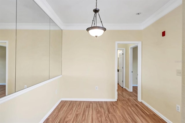 unfurnished room featuring crown molding, wood finished floors, and baseboards