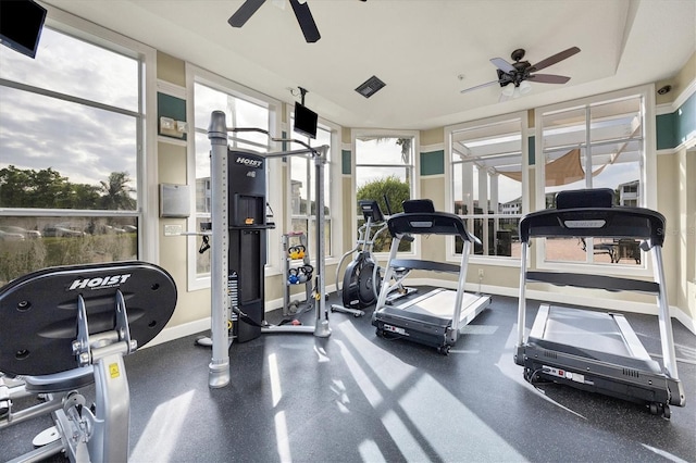 gym featuring a ceiling fan and baseboards