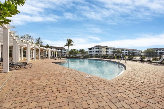 pool with a residential view, a patio, fence, and a pergola