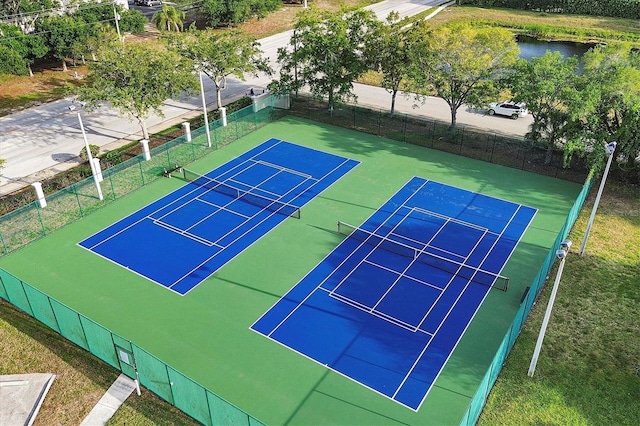 view of sport court featuring a water view and fence