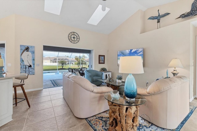 living room featuring a skylight, light tile patterned flooring, baseboards, and high vaulted ceiling